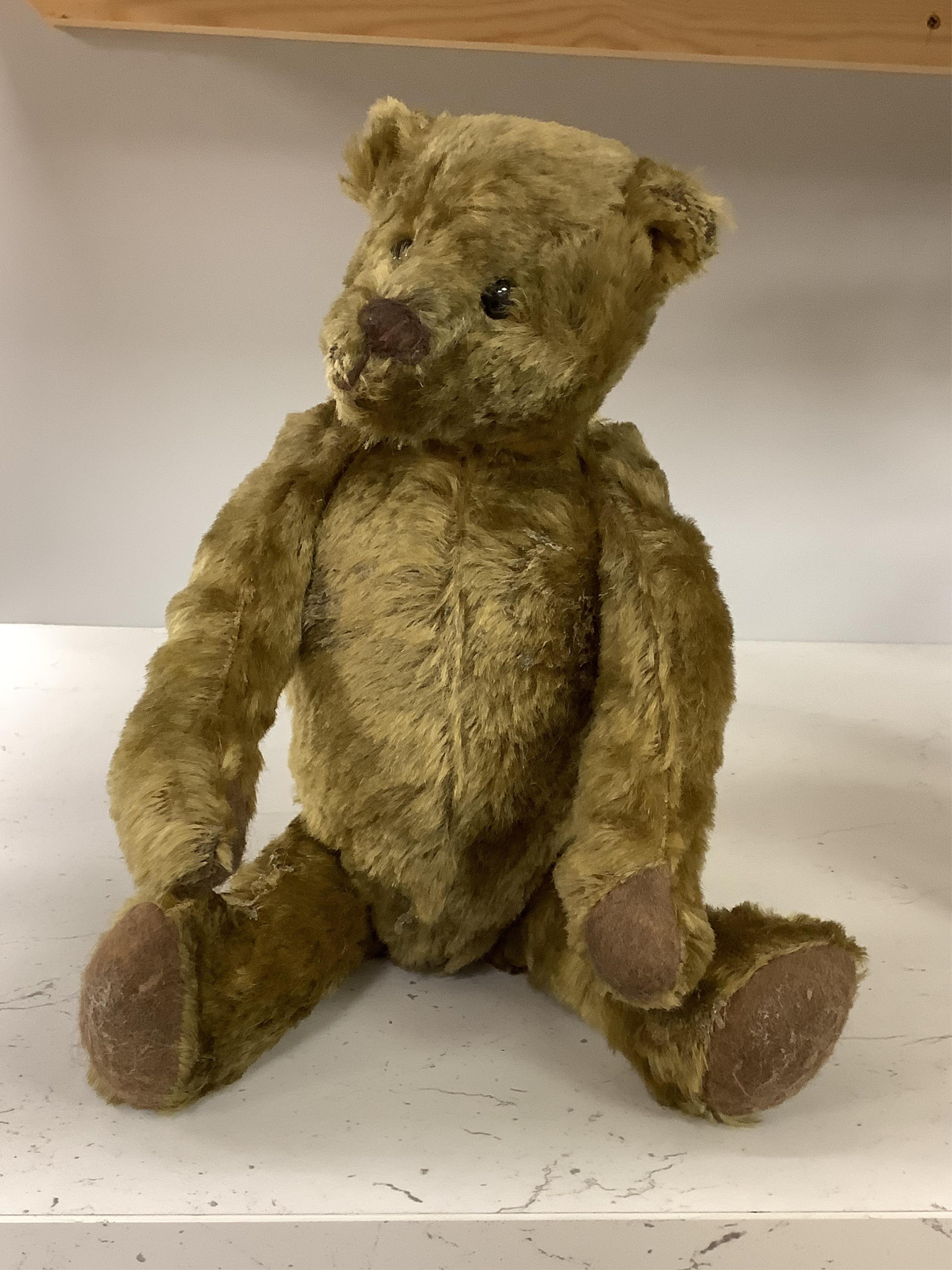 An early 20th century German hump backed plush teddy bear and three others, German teddy 30cm high. Condition - the German teddy has a short split on the back seam and glue on the front leg that needs removing and plush